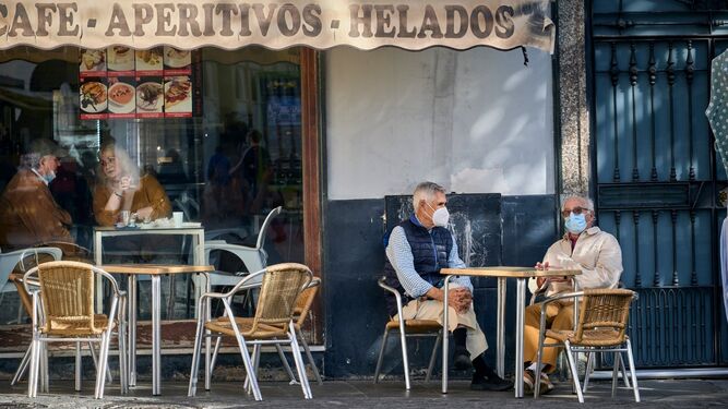 Dos personas con mascarilla en una terraza de Cádiz.