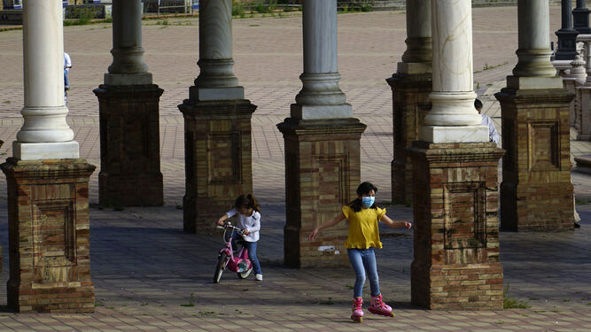 Dos niñas juegan en la Plaza de España de Sevilla.