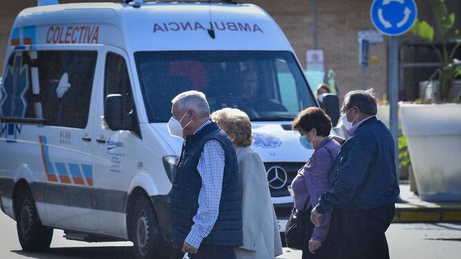 Varias personas en el entorno hospitalario del Macarena, con una ambulancia al fondo.