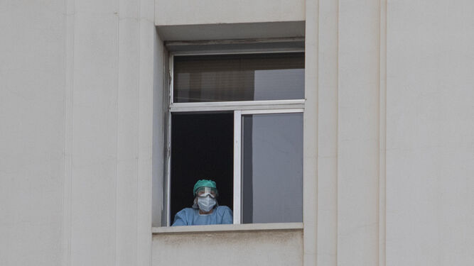 Una profesional se asoma a una ventana del Hospital Virgen de las Nieves de Granada