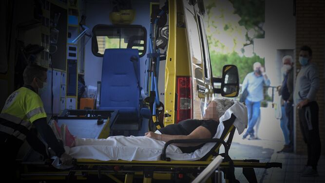 Una mujer es traslada en camilla por el personal sanitario desde una ambulancia.
