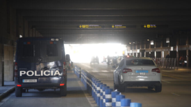 Un furgón policial junto a un taxi en el aeropuerto de Sevilla.