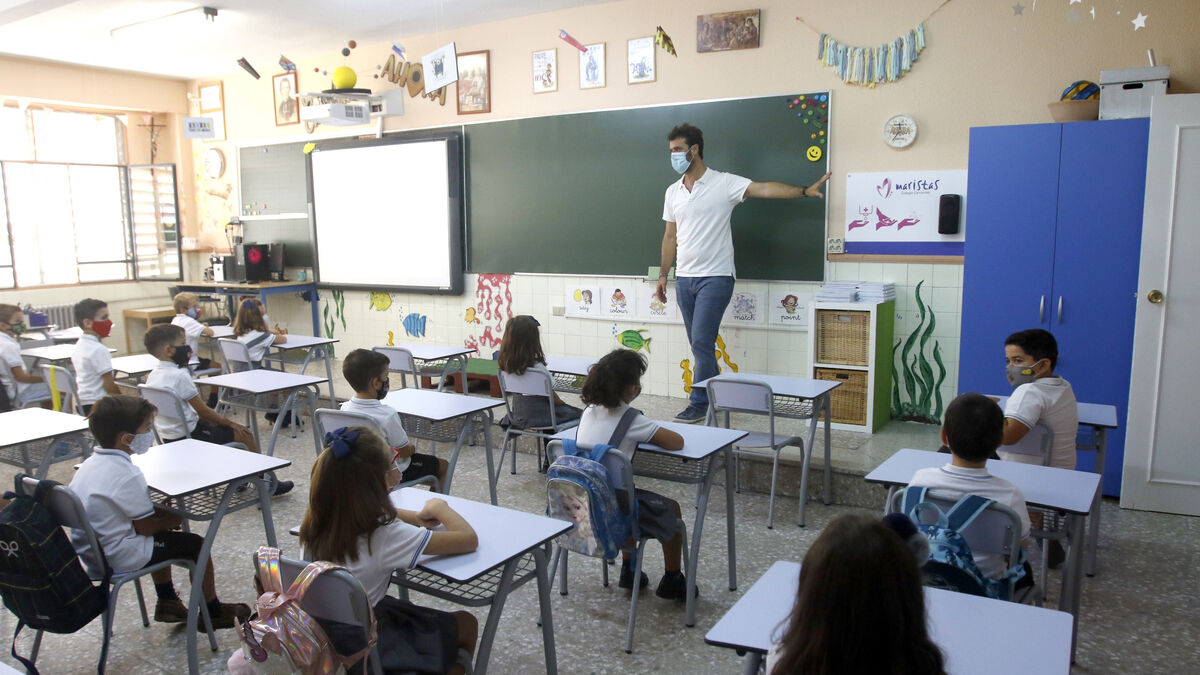 Un maestro imparte clases a alumnos de Primaria en un aula donde todos llevan mascarillas.
