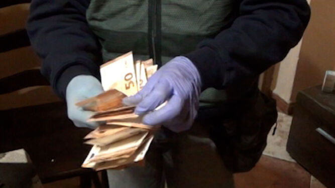 Un guardia civil muestra el dinero intervenido en la operación.