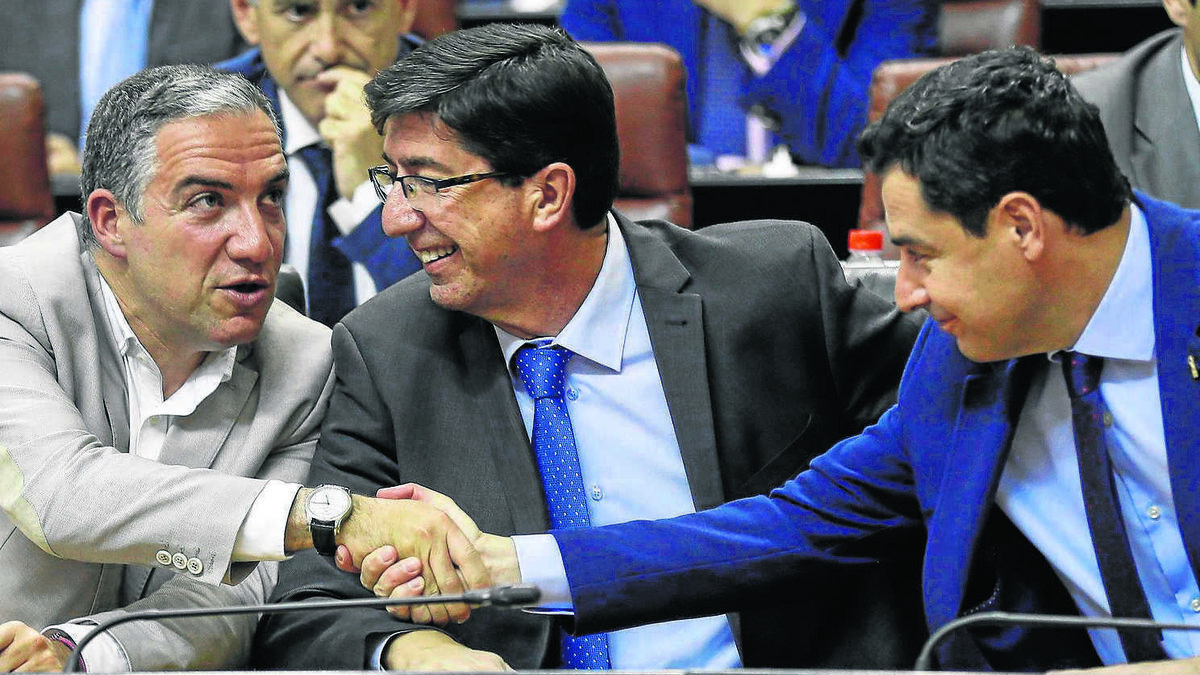 Elías Bendodo y Juanma Moreno se estrchan la mano en el Parlamento en presencia de Juan Marín.