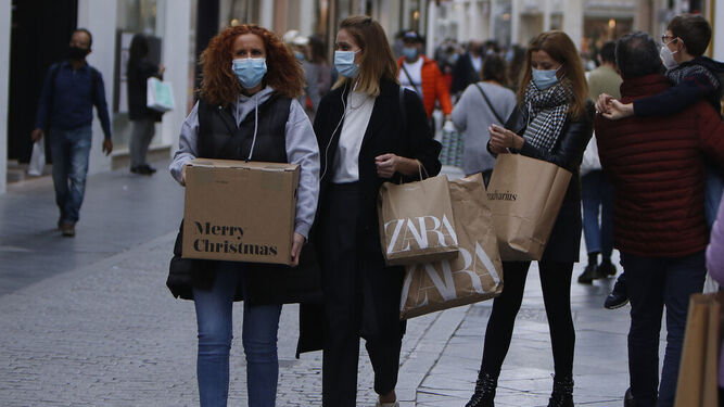Varias mujeres pasean con sus compras por el centro de Sevilla.