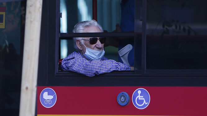 Un usuario de Tussam con mascarilla en el interior de un autobús.