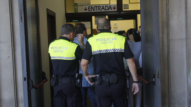 Dos policías locales acceden a los juzgados de Sevilla.