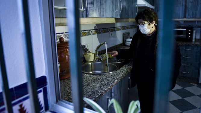 Una vecina de Arahal, uno de los municipios afectados por la presencia de benceno en el agua, abre el grifo de su cocina.