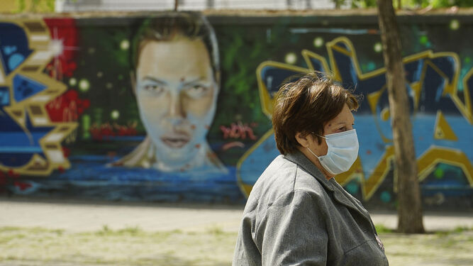 Un mujer con mascarilla en Tres Barrios-Amate, una de las zonas con mayor pobreza de la ciudad.