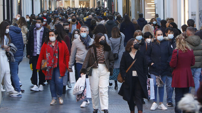 Decenas de personas coinciden en una céntrica calle comercial de Sevilla.