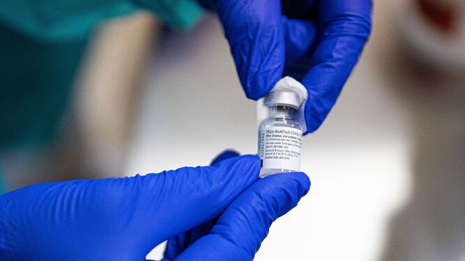 Un sanitario porta un vial de la vacuna en sus manos