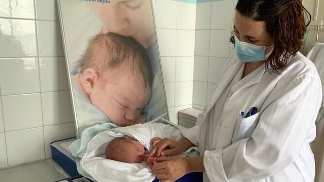 La enfermera Luz María Castillo llevando a cabo una pulsioximetría a un recién nacido en la Maternidad de Valme, prueba incluida dentro del programa de cribado instaurado.