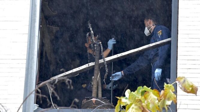 Agentes de la Policía Científica en la ventana destrozada del ala Norte donde se originó el incendio en la residencia.