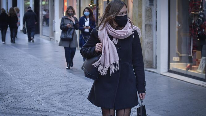 Varias mujeres pasean por el centro de Sevilla con mascarilla para evitar el contagio del Covid.