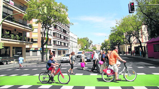 Un niño y un adulto circulando por Sevilla en bicicleta.