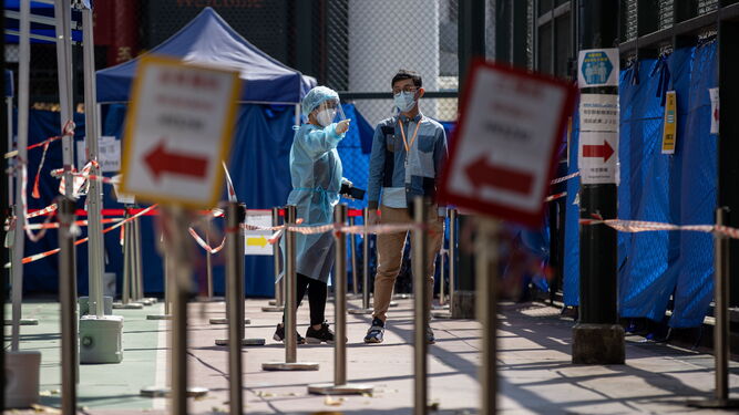Una sanitaria indica la entrada a un centro de test de coronavirus en Hong Kong.