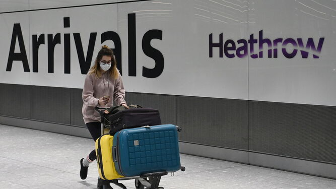 Una joven empuja su equipaje en el aeropuerto de Heathrow de Londres.