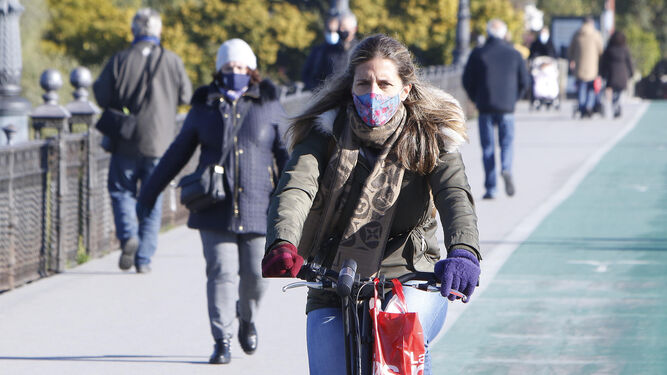 Una mujer en bici y protegida del frío.