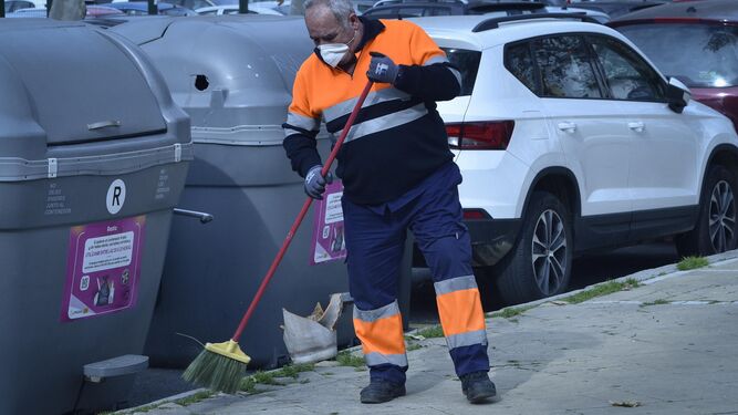 Un operario de la empresa de limpieza barre una acera de la ciudad.