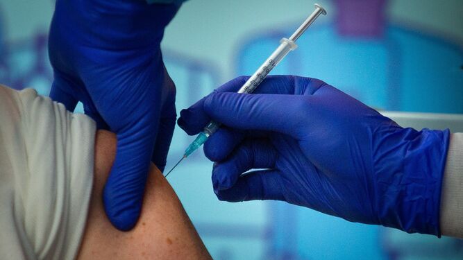 Un sanitario pone una vacuna a un paciente