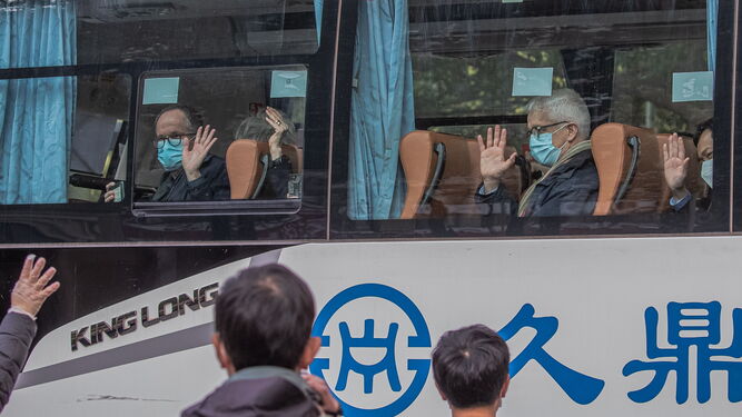 Los expertos de la OMS saludan desde un autobús en Wuhan
