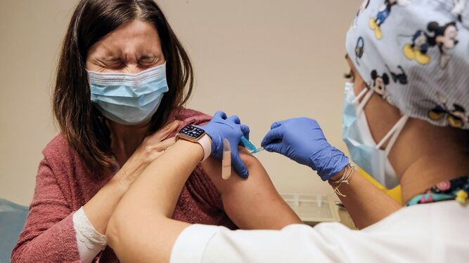 Una enfermera administra una vacuna contra el Covid-19 a una sanitaria.