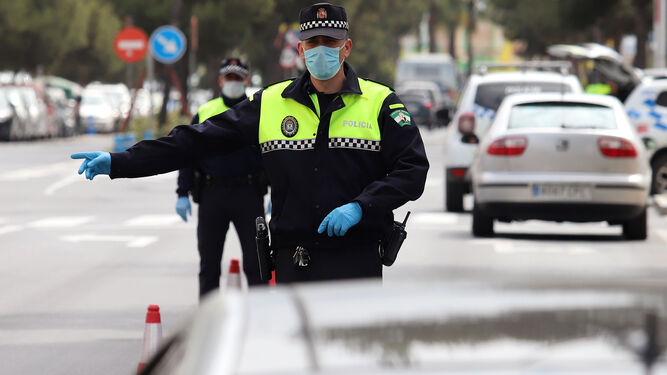 Dos agentes de Policía se protegen con mascarillas y guantes durante un control de tráfico.