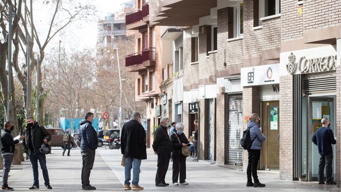 Varias personas hacen cola en una oficina de Correos de Barcelona este viernes, último día para admitir peticiones de voto por correo para el 14-F.