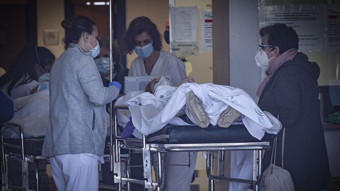 Dos sanitarias reciben a una paciente en las Urgencias del Hospital de Valme.