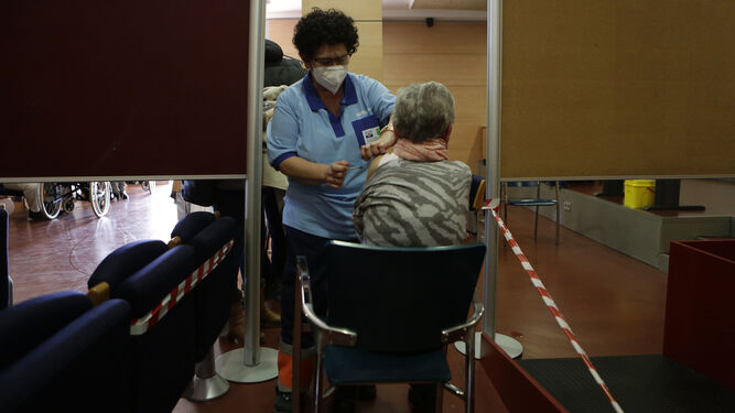 Una señora recibe la vacuna en Sevilla, en uno de los puntos habilitados por la Junta para inmunizar a los mayores de 80 años que no están en residencias.