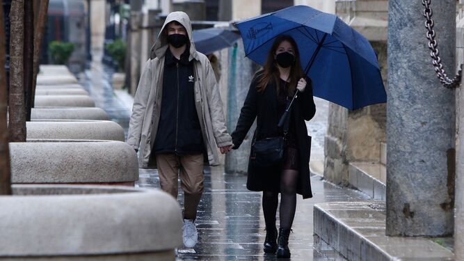 Una pareja camina bajo la lluvia este domingo por el centro de Sevilla.