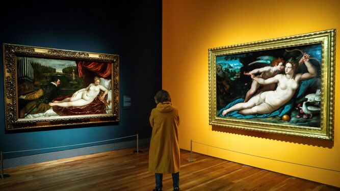 Una visitante entre 'Venus recreándose en la música' y 'Venus y Cupido' (derecha) de Tiziano.