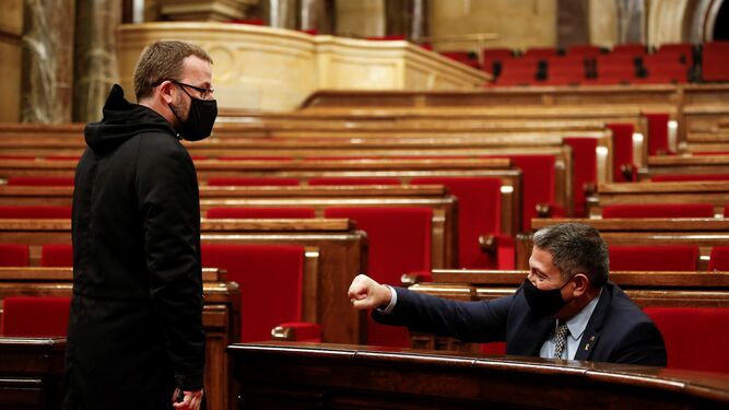 El 'conseller' de Interior, Miquel Sàmper, conversa con el diputado de la CUP, Vidal Aragonés (i).