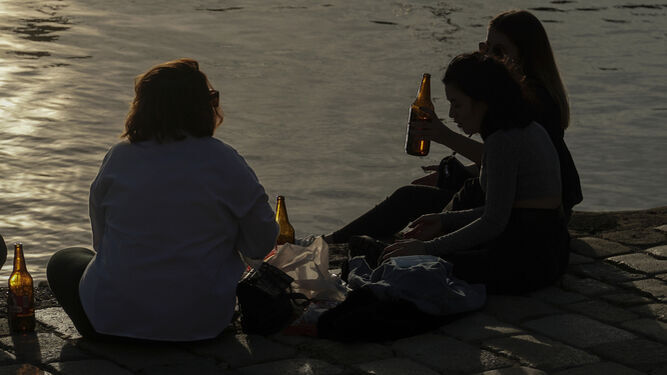 Jóvenes bebiendo junto al río durante la pandemia