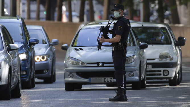 Un agente de la Policía Nacional vigila durante un control de carreteras en Sevilla.