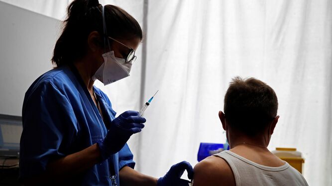 Una profesional sanitaria administra la vacuna contra la COVID-19 a un ciudadano en Barcelona.