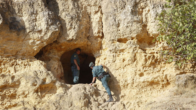 Dos guardias civiles buscan a una anciana desaparecida en una cueva de Carmona.