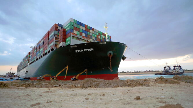 Un remolcador cerca del buque portacontenedores ‘Ever Given’, que sigue encallado en el canal de Suez desde el martes pasado.