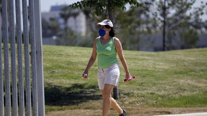 Una mujer pasea por un parque de Sevilla