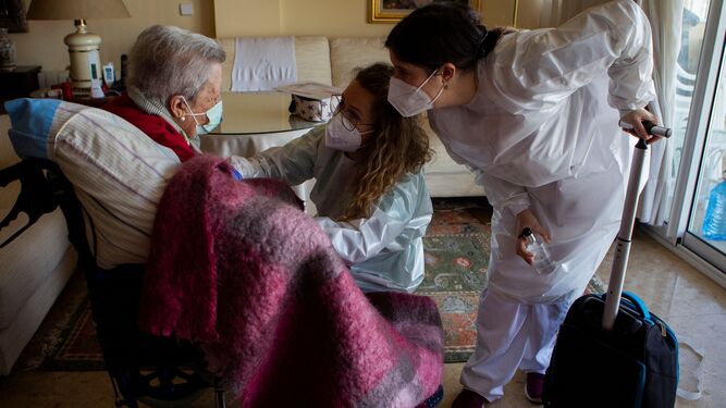 Dos enfermeras vacunando a una  anciana en su domicilio en Palma de Mallorca.