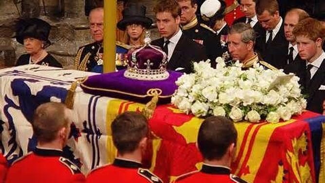 Los príncipes Guillermo y Enrique, separados por su padre, el príncipe de Gales, en el funeral de la reina madre en 2002.