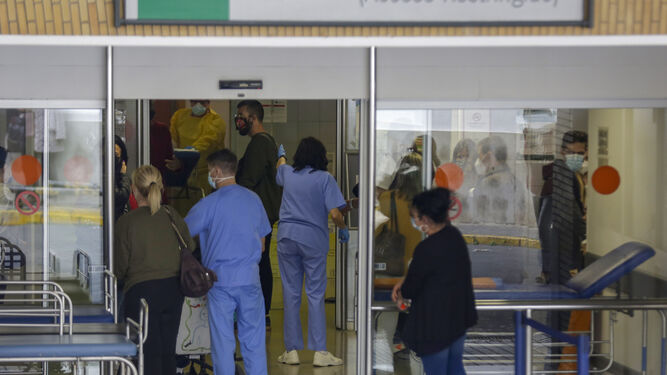 Varias personas y algunos sanitarios en uno de los accesos a las Urgencias del Virgen del Rocío.