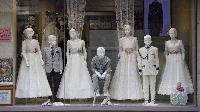 Un escaparate de una tienda dedicada a la venta de trajes y vestidos para niños y niñas de primera comunión