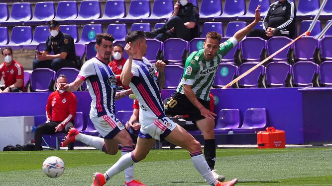 Canales centra raso ante dos jugadores del Valladolid.