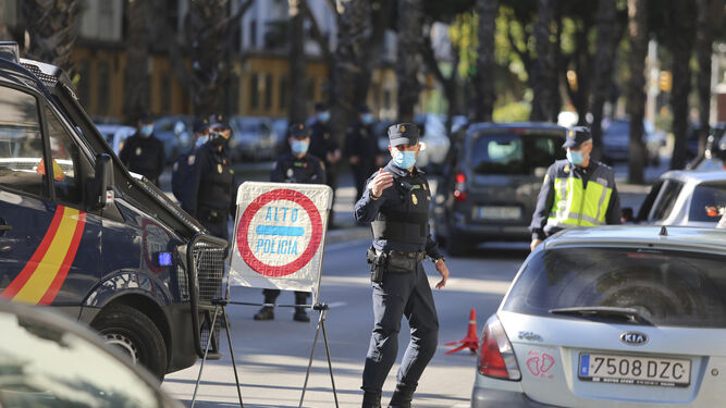 Un agente de la Policía Nacional efectúa labor de control de las salidas de los vehículos en Málaga.