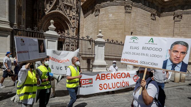 Trabajadores de Abengoa, durante la protesta de ayer, pasan por delante de laCatedral de Sevilla.