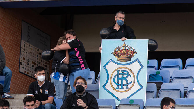 Aficionados del Recreativo de Huelva, desolados por el descenso de su equipo, portan globos negros.