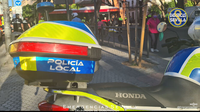 Una moto de la Policía Local, con el autobús del accidente al fondo.