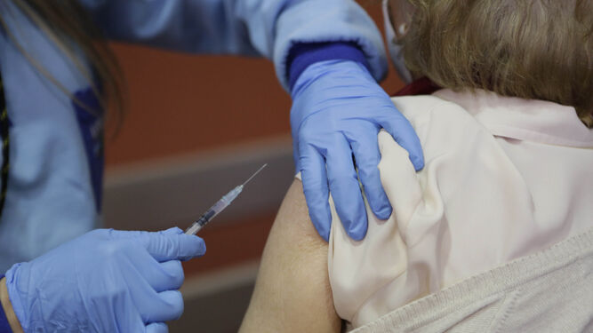 Una enfermera en el momento de inyectar la vacuna  contra la Covid a una mujer .